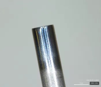 Einzelnes, senkrecht stehendes Edelstahl-Feinrohr in Nahaufnahme, mit glatter, reflektierender Oberfläche.
